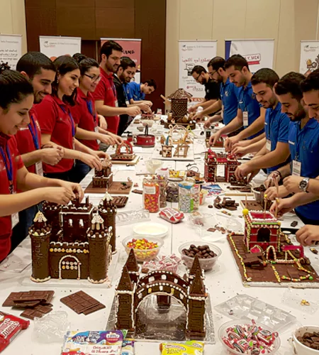 Chocolate Builders Challenge team-building activity in Dubai with employees constructing edible chocolate structures, enhancing creativity, teamwork, and problem-solving skills