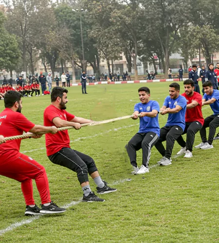 Survivor Champions team-building activity in Dubai featuring employees competing in a tug-of-war challenge, fostering teamwork, resilience, and leadership skills.