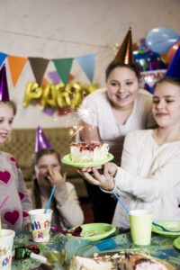 Girls excitedly looking at a cake with a sparkler during a celebration organised by MRM Events in Dubai