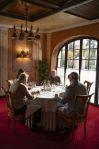 Group dining in an elegant restaurant with large windows and wine glasses during an upscale MRM Events function in Dubai