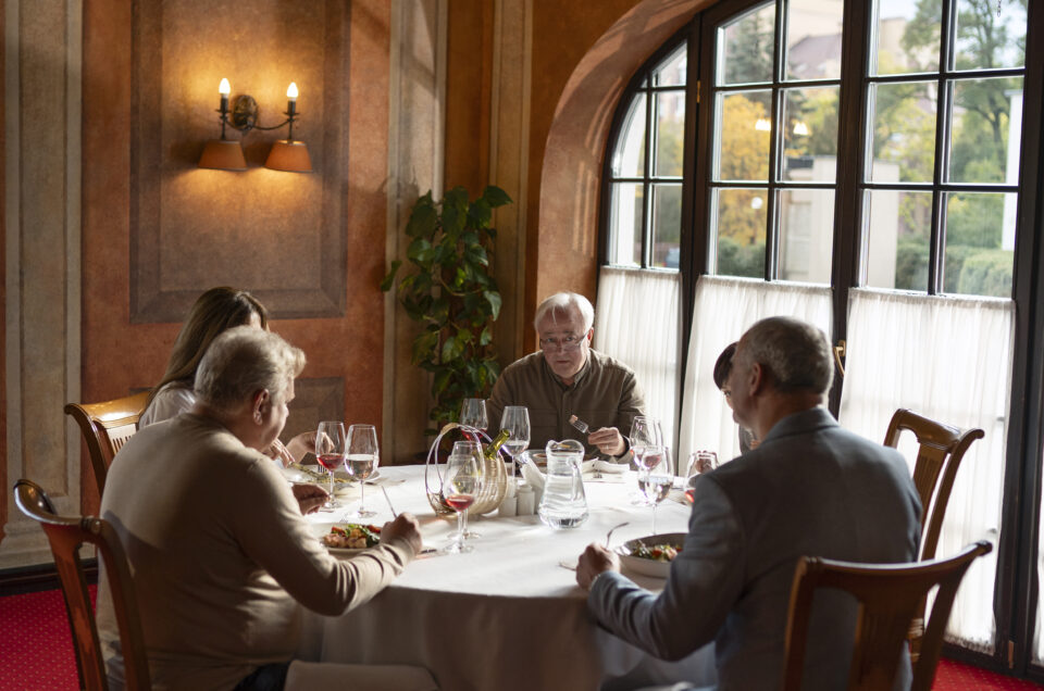 Group dining in an elegant restaurant with large windows and wine glasses during an upscale MRM Events function in Dubai