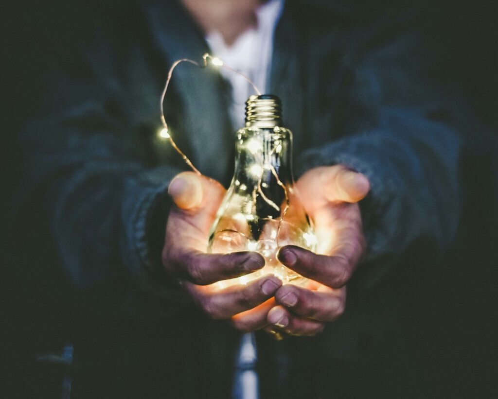 Hands holding a light bulb filled with fairy lights, symbolising bright ideas and innovation by MRM Events.