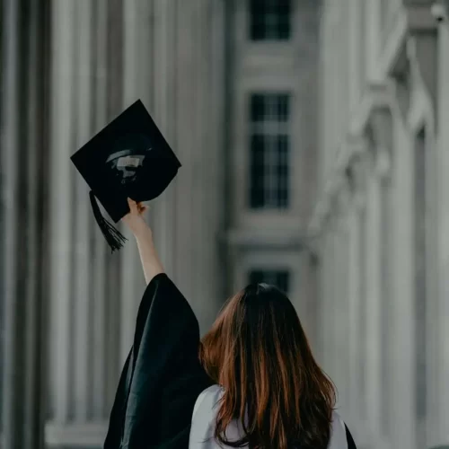 Graduate raising her cap in celebration, representing MRM Events' academic ceremonies.
