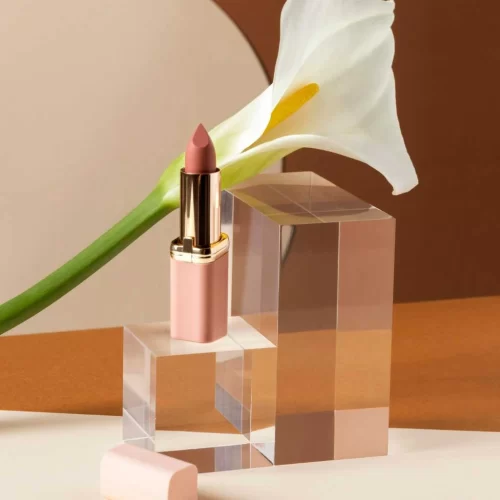 Makeup product display with lipstick and white lily on acrylic blocks, representing MRM Events' styling for product launches.