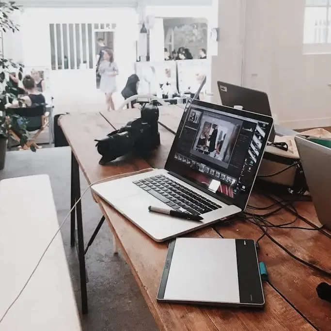 Modern workspace with laptop, DSLR camera and drawing tablet, reflecting MRM Events' creative planning environment.