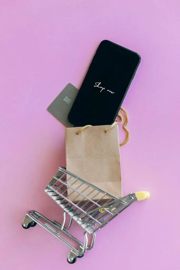 Mini shopping cart with a smartphone displaying 'Shop now' and a credit card, suggesting e-commerce and promotional campaigns managed by MRM Events.