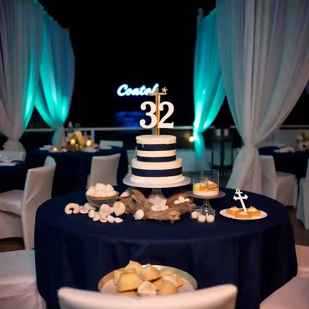 Elegant nautical-themed 32nd birthday setup with a striped cake, seashell decor, and ocean-inspired ambiance.