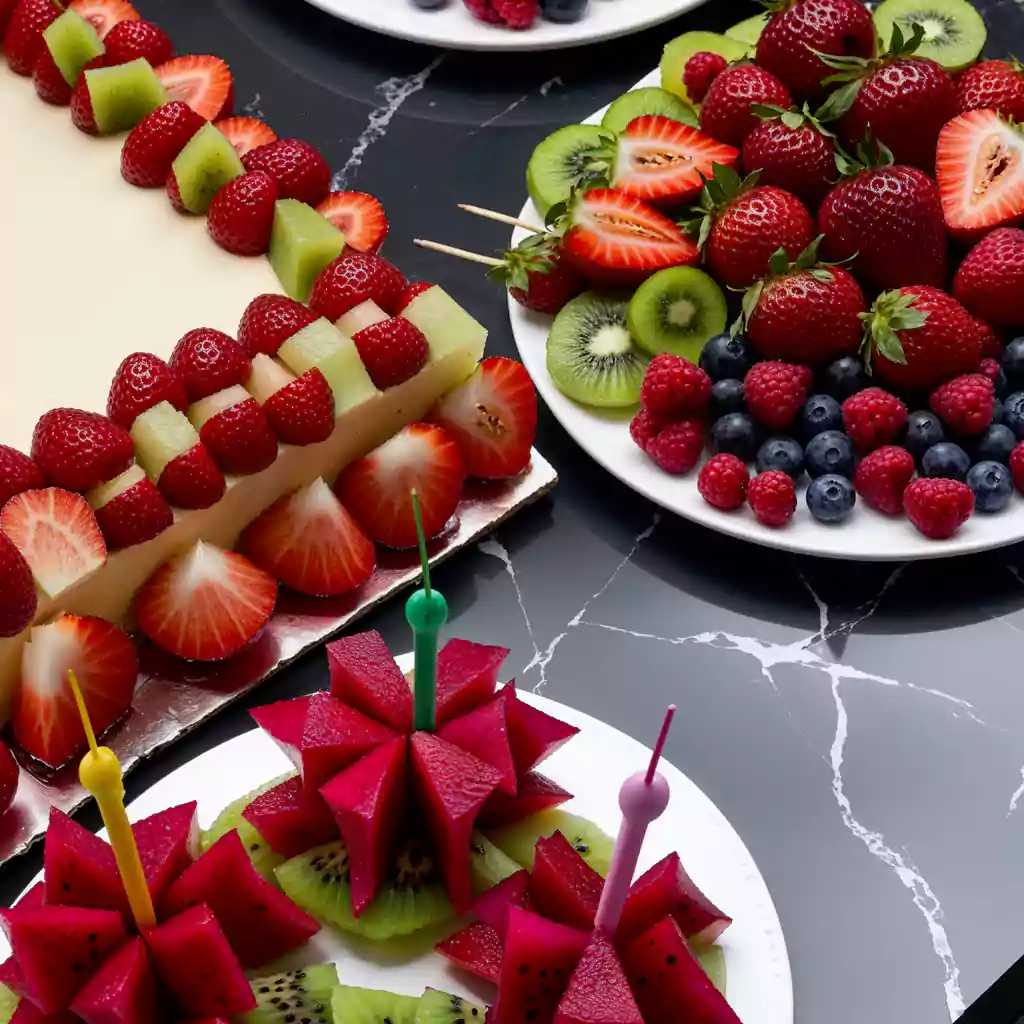private catering with a fresh fruit dessert table featuring strawberry cake, kiwi, dragon fruit, and berries, perfect for upscale events