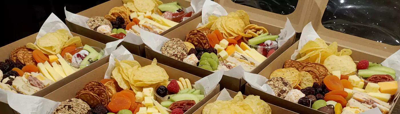 "Individual snack boxes for business meeting catering, filled with fruits, cheese, and chips, ideal for corporate catering in Dubai