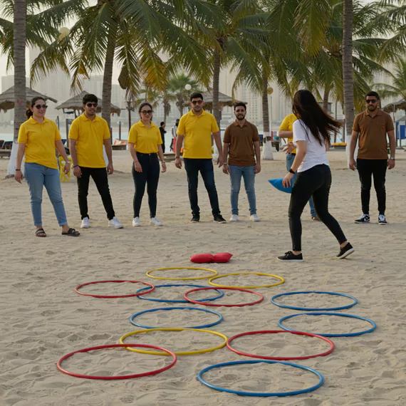 Outdoor team-building activity in Dubai featuring employees playing a strategic beach ring toss game, enhancing teamwork, coordination, and problem-solving skills