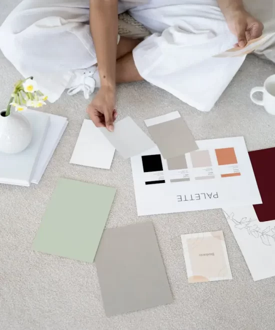 Designer hand selecting colour swatches from a palette next to paint chips, illustrating creative branding work for MRM Events.